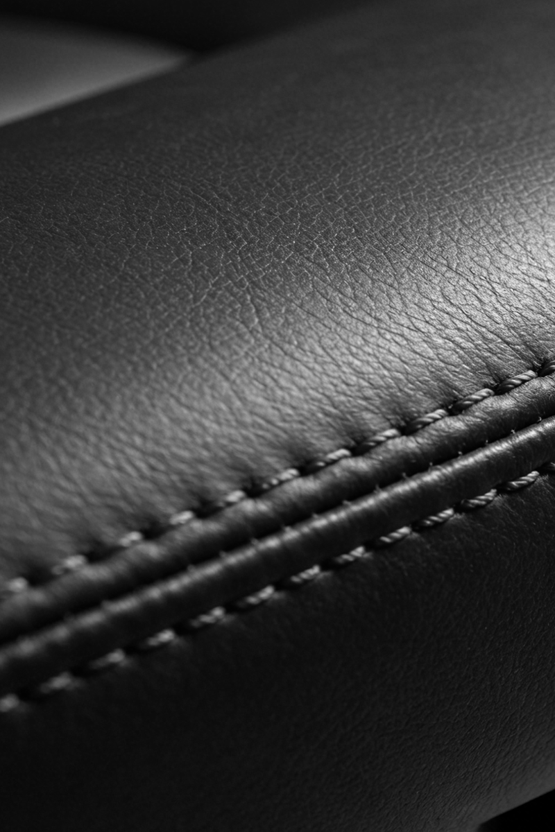 Close up of black textured leather or vinyl material with double stitching